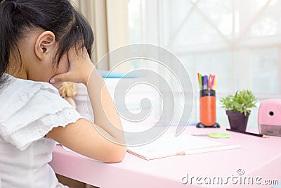 Decent school child. holding her head with a hand and reading a book Stock Photo