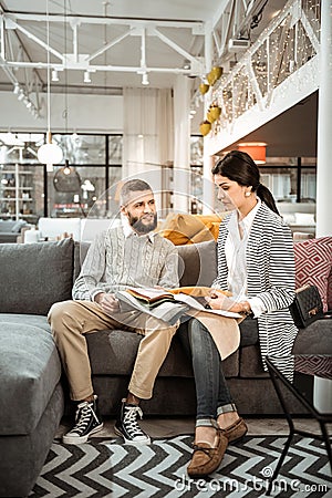 Concentrated couple attentively inspecting colorful samples and discussing Stock Photo