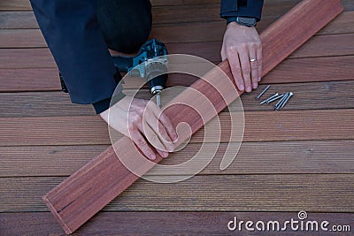 Deck installation carpenter hands holding ipe board, terrace decking construction wood work Stock Photo