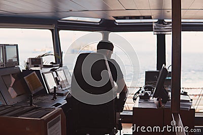Deck navigation officer on the navigation bridge. He looks at radar screen Stock Photo