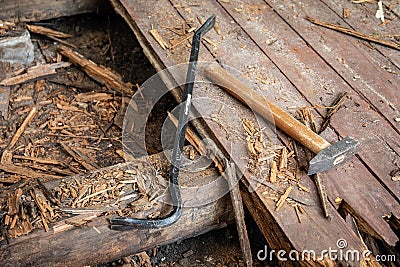 Deconstruction of old wooden floor, crowbar and hummer on the ground, preparing for renovation Stock Photo