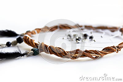 Decor with your own hands. Dreams catcher made of willow vines, feathers, white threads, and beads close-up on a white background Stock Photo