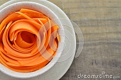 Decorate cup with slices carrots on wooden table Stock Photo