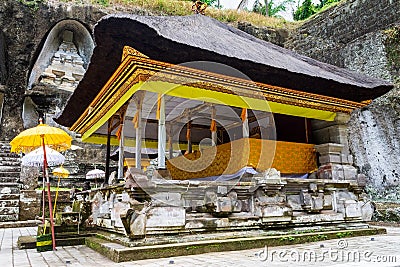 Decorated altar for celebration with textiles and tedung umbrellas by the funeral monuments of Gunung Kawi, Bali, Indonesia. Stock Photo