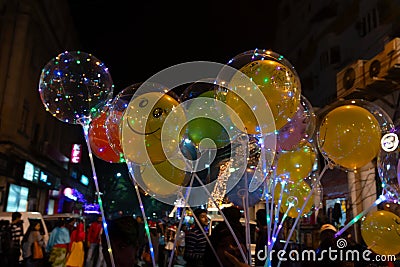 Decorated balloons, lights and Christmas celebration at illuminated Park street with joy and year end festive mood. Dark sky Editorial Stock Photo