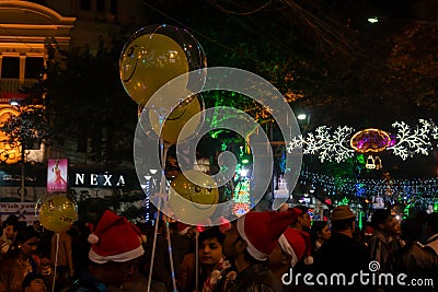 Decorated balloons, lights and Christmas celebration at illuminated Park street with joy and year end festive mood. Dark sky Editorial Stock Photo