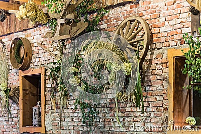 Decorated brick wall with farmer tools and wheat and leaves Stock Photo