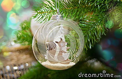 Decorated Christmas tree and hanging small ball with funny squirrel toy inside Stock Photo
