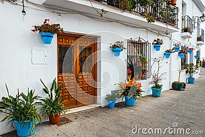 Decorated facade of house with flowers in blue pots Stock Photo