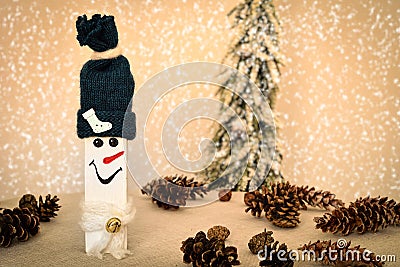 Decorated handmade wooden snowman with pine cones on the snowy background Stock Photo