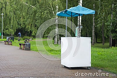 Decorated lemonade stand in park. Summer refreshing natural drink. White lemonade stall with tent and cranes. White street stall Stock Photo