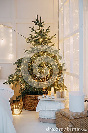 Decorated mirror and live Christmas tree with lights. New year's interior, festive atmosphere, decor, garlands Stock Photo