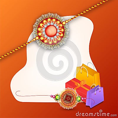Decorated rakhi with gift box and shopping bag on shiny orange b Stock Photo