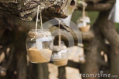 decorated romantic place for a date with jars full of candles hunging on tree. Copy Space Stock Photo