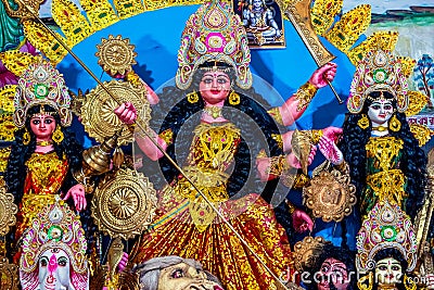 Decorated sculpture of goddess Durga idol on lion with ten arms at pandal and temple in colored light. Durga Puja is big cultural Stock Photo