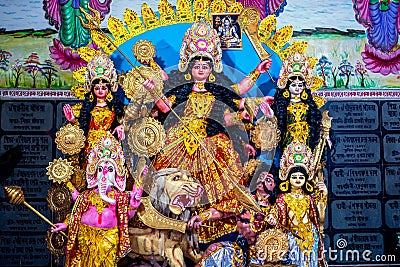 Decorated sculpture of goddess Durga idol on lion with ten arms at pandal and temple in colored light. Durga Puja is big cultural Stock Photo