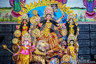 Decorated sculpture of goddess Durga idol on lion with ten arms at pandal and temple in colored light. Durga Puja is big cultural Stock Photo