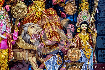 Decorated sculpture of goddess Durga idol on lion with ten arms at pandal and temple in colored light. Durga Puja is big cultural Stock Photo