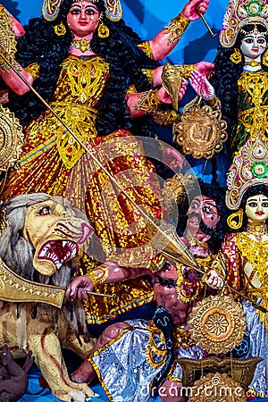 Decorated sculpture of goddess Durga idol on lion with ten arms at pandal and temple in colored light. Durga Puja is big cultural Stock Photo