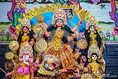 Decorated sculpture of goddess Durga idol on lion with ten arms at pandal and temple in colored light. Durga Puja is big cultural Stock Photo