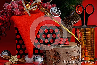 Decorating a gift with New Year's tinsel on a red background. Stock Photo