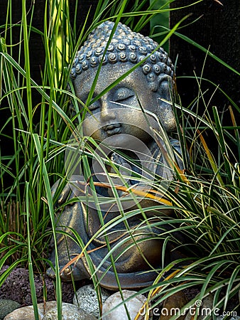 Decoration buddha statue little in a garden outdoor covered with grass Stock Photo