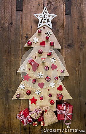 Decoration: handmade carved christmas tree with red miniatures. Stock Photo