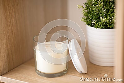 Fragrance candle in glass holder on shelving Stock Photo