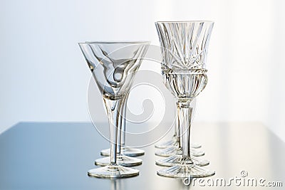 Decoration setup of wine and martini glasses set up in rows on a reflective table top Stock Photo