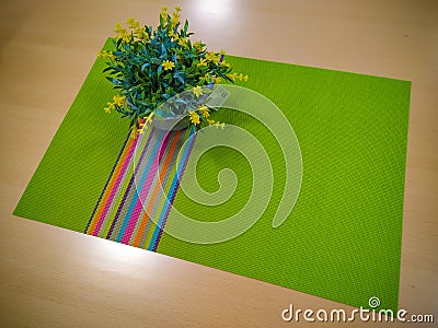 Decoration on the table consisting of green dining tablecloth and fake yellow flowers in a pot Stock Photo
