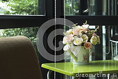 Decoration watering can with artificial flowers in the coffee ca Stock Photo