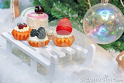 Decorations in the form of a variety of cakes on the background of the Christmas tree Stock Photo