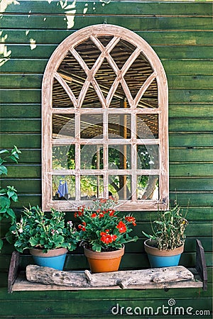 Decorative arched window mirror hanging on a wooden wall. Country style decoration Stock Photo