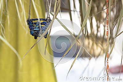 Decorative basket hanging on the roof. Dried leaves hanging down from the roof. Bead decorations on basket Stock Photo