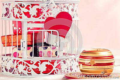 Decorative birdcage, presents, heart and candle. Stock Photo