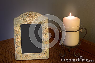 Decorative blank photo frame with lit candle on dresser Stock Photo