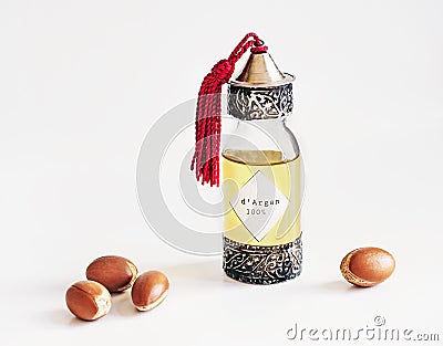 Decorative bottle with iron embossed in traditional Moroccan style with precious Moroccan argan oil and argan nuts on an Stock Photo