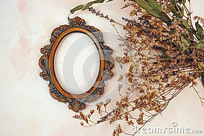 Decorative bronze vintage oval photo frame and dried flowers. Stock Photo