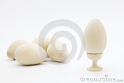 Christian Easter.A wooden egg for coloring on a stand stands next to a pile of eggs Stock Photo