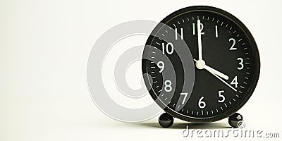 Decorative close-up black analog alarm clock for 4 or 16 o`clock, separate white background with copy space Stock Photo