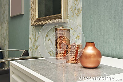Decorative copper containers on a white chest of drawers and Stock Photo