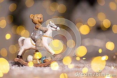 Decorative figurines of a Christmas theme. Figurine of a little teddy bear on a rocking horse. Christmas tree decoration. Festive Stock Photo