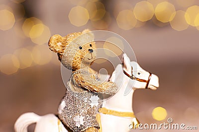 Decorative figurines of a Christmas theme. Figurine of a little teddy bear on a rocking horse. Christmas tree decoration. Festive Stock Photo