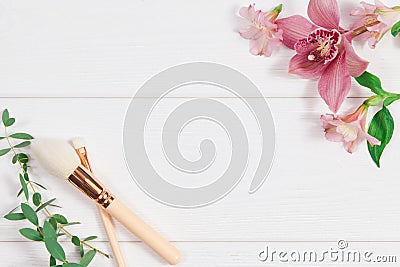 Decorative flat lay composition with makeup products and flowers. Flat lay, top view on white background. Stock Photo