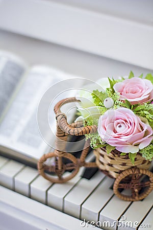 Decorative flowers roses in a wicker bicycle on the piano and the Bible. Topiary. Wedding decor, decoration. Stock Photo