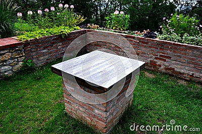 Decorative garden behind the wall, with a wooden table and decorative trellis for climbing plants or for garden wedding ceremonies Stock Photo
