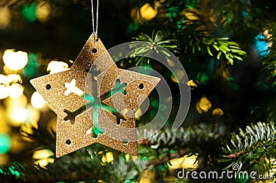 Decorative Gold star ornament in a Christmas tree Stock Photo