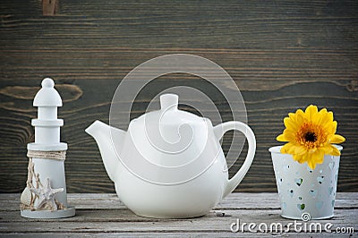 Decorative lighthouse, white teapot and yellow flower Stock Photo