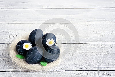 Eggs in a decorative white nest are painted for Easter celebration. Festive decor for breakfast Stock Photo