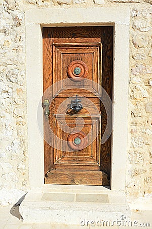 Decorative massive wooden vintage door with smithcrafted decorative doorknocker on church in Razanac Stock Photo
